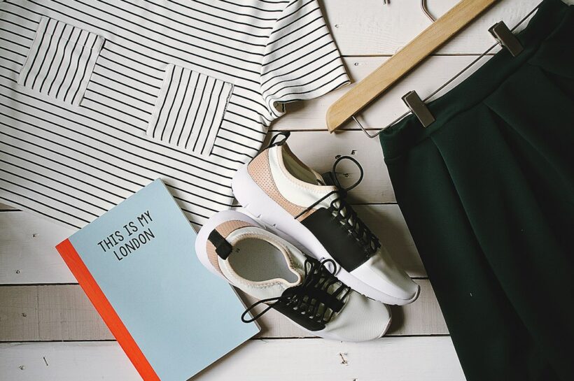Editorial flat lay showing capsule wardrobe essentials in a neutral palette
